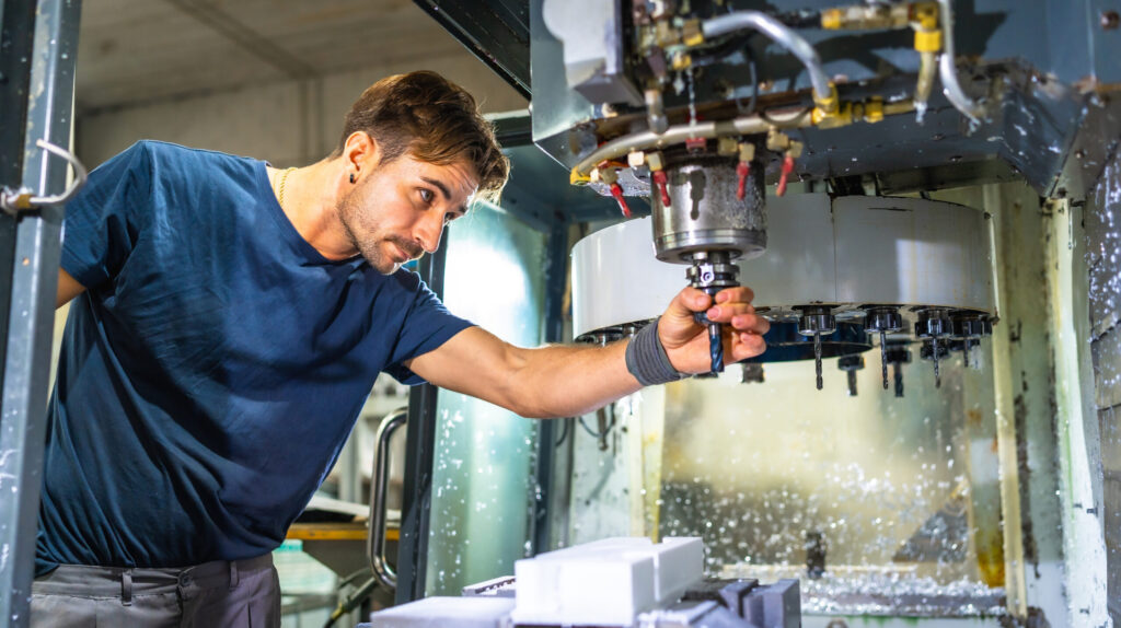 Techniker an einer CNC-Werkzeugmaschine – technische Dokumentation und Betriebsanleitung im Maschinenbau